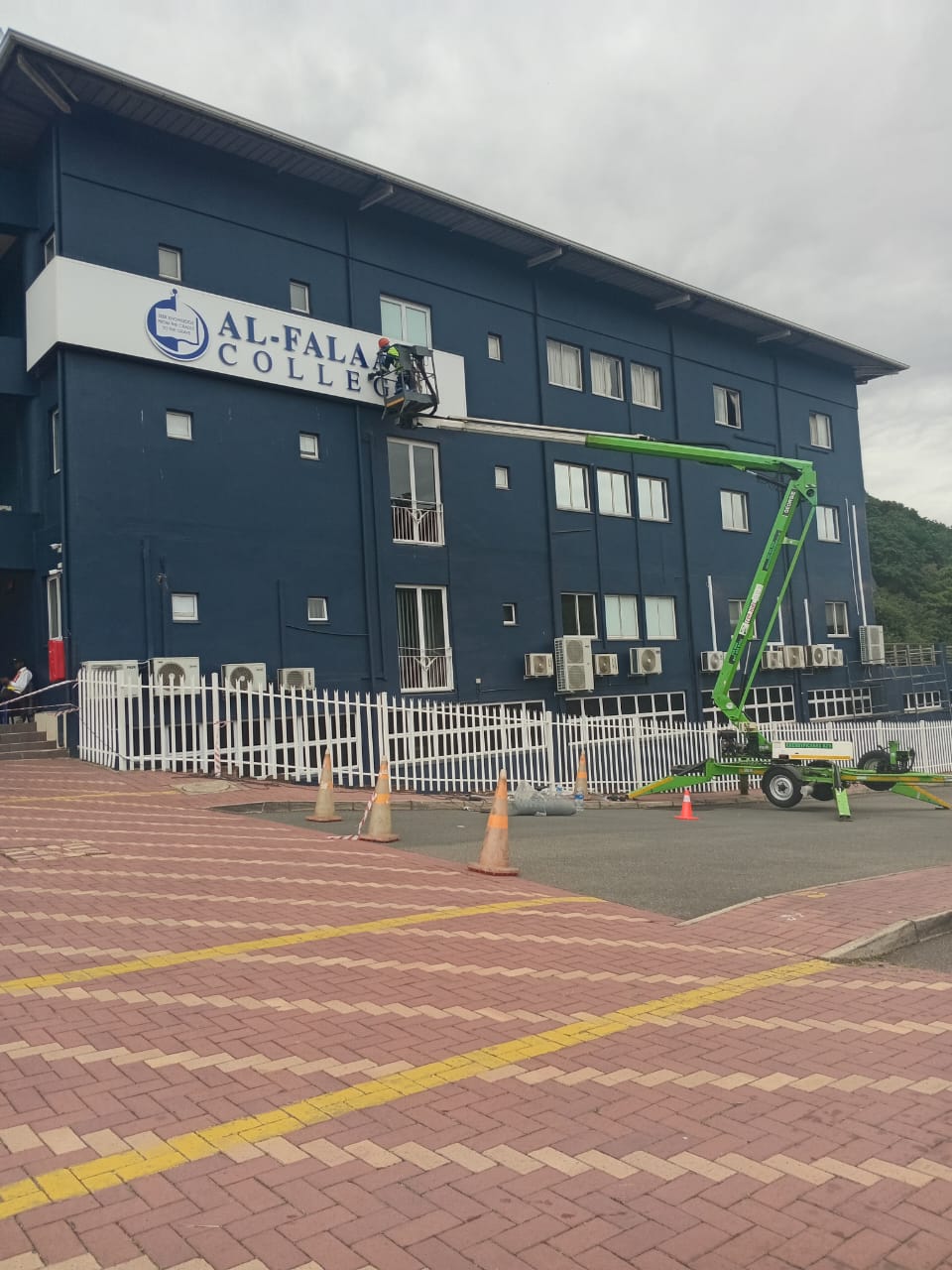 Bird-control technician working from an elevated platform at a commercial building