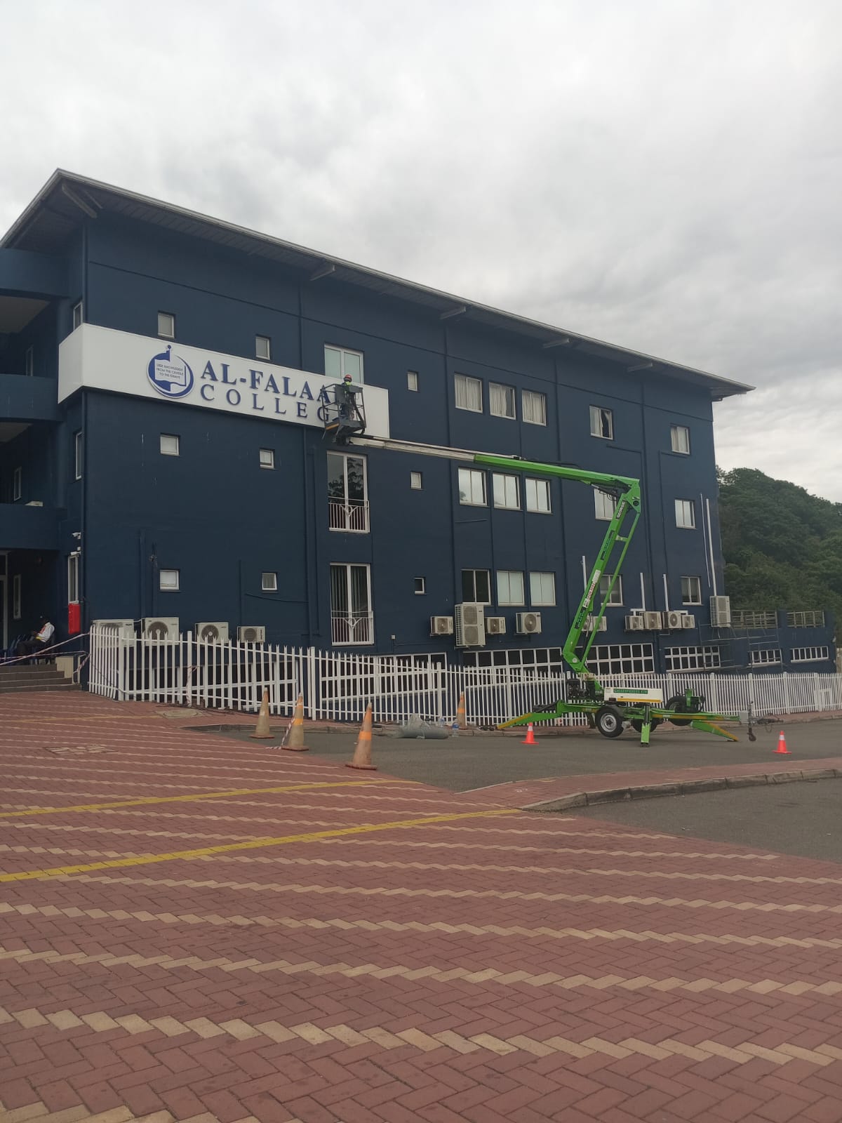 Technician carrying out bird-control work from an elevated platform at a commercial property