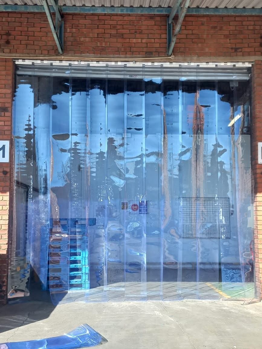 Clear plastic strip curtain installed across an industrial opening